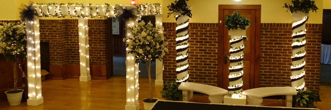Picture of a decorated chuppah, columns, benches and topiaries