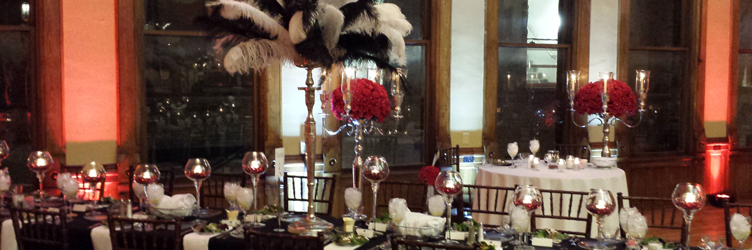 Picture of silver floor and table candelabras, glass brandy snifters, red accents, red roses